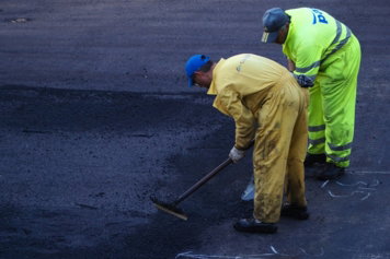two man construct road during daytime