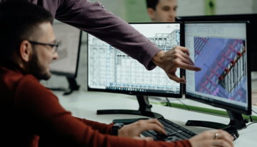 Colleagues collaborate while examining computer designs.